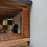 Zabudowa tarasu z deskami Impra Miód Manuka, drewniane elementy i pergola.
