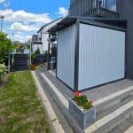 Zabudowa tarasu z lamelami RAL 9006DS pion na nowoczesnym domu.