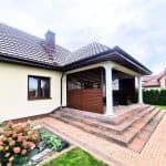 Przesuwna zabudowa tarasu lamele aluminium. Nowoczesny taras z podestem i kolumnami, idealny do relaksu na świeżym powietrzu.