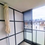 Zabudowa balkonu z aluminiowymi lamelami. Balkon z nowoczesnym ogrodzeniem i widokiem na miasto.