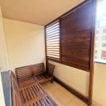 Zabudowa balkonu z drewnianymi lamelami. Balkon z drewnianymi meblami i osłonami z drewna, widok na miasto.