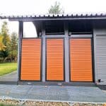 Zabudowa boczna tarasu z lamelami poziom aluminium. Nowoczesne drzwi z drewnianymi panelami do domu jednorodzinnego.