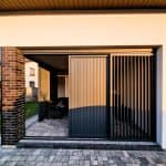 Zabudowa tarasu z lamelami aluminium pion. Nowoczesne ogrodzenie z metalowych lameli i brama wjazdowa do domu.