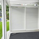 Przesuwna zabudowa tarasu z aluminium RAL 7047. Białe rolety zewnętrzne na tarasie, nowoczesny design i ochrona przed słońcem.