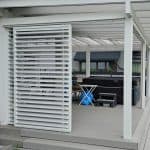 Przesuwna zabudowa tarasu z aluminium RAL 7047. Przytulny taras z jacuzzi i miejscem do relaksu na świeżym powietrzu.