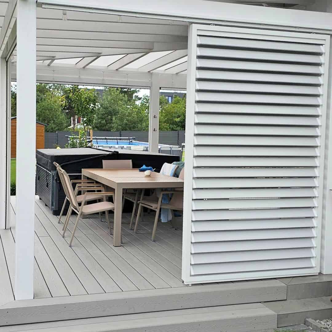 Przesuwna zabudowa tarasu z aluminium RAL 7047. Taras z meblami ogrodowymi i pergolą w nowoczesnym stylu.