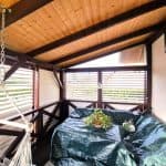 Przytulny balkon z drewnianym sufitem i roślinami na stole.