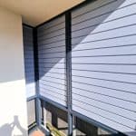 Zabudowa balkonu z aluminium RAL 7001. Nowoczesne osłony balkonowe z aluminium i roletami antywłamaniowymi.